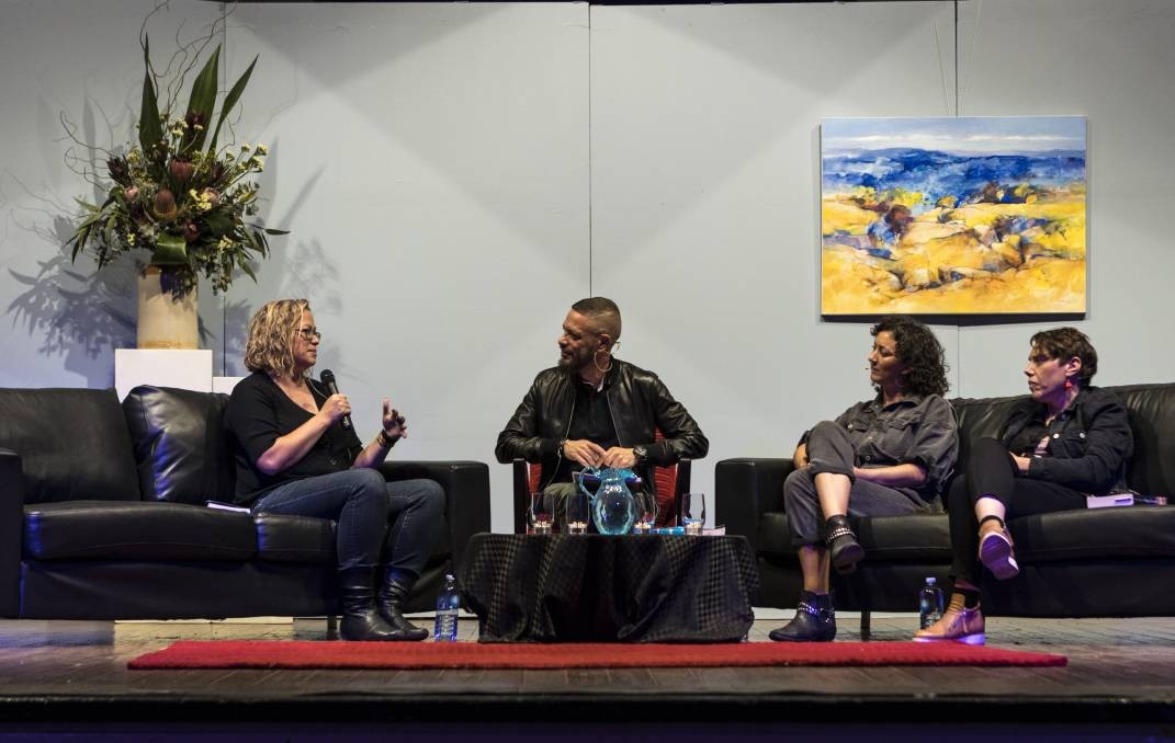 A view of a theatre stage mid-writers festival panel with a painting and flowers in the background Lisa Fuller Daniel Browning Mykaela Saunders and Nardi Simpson sit on couches 
