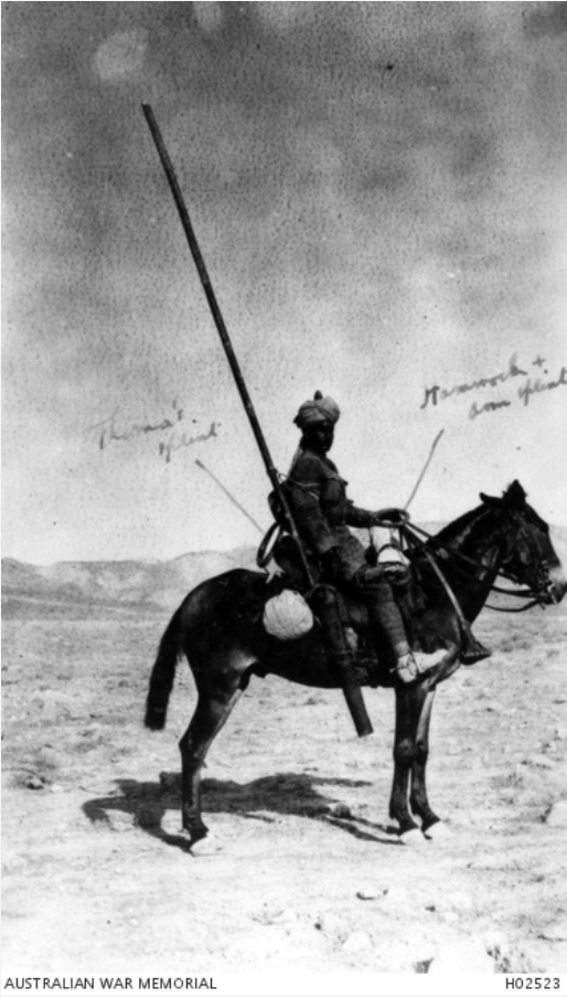 Man wearing turban sitting on a donkey in the desert with medical equipment including a leg splint