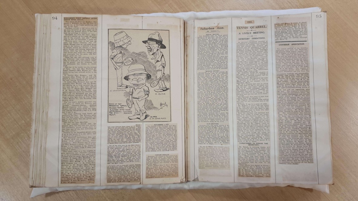 Several news items pasted into open book