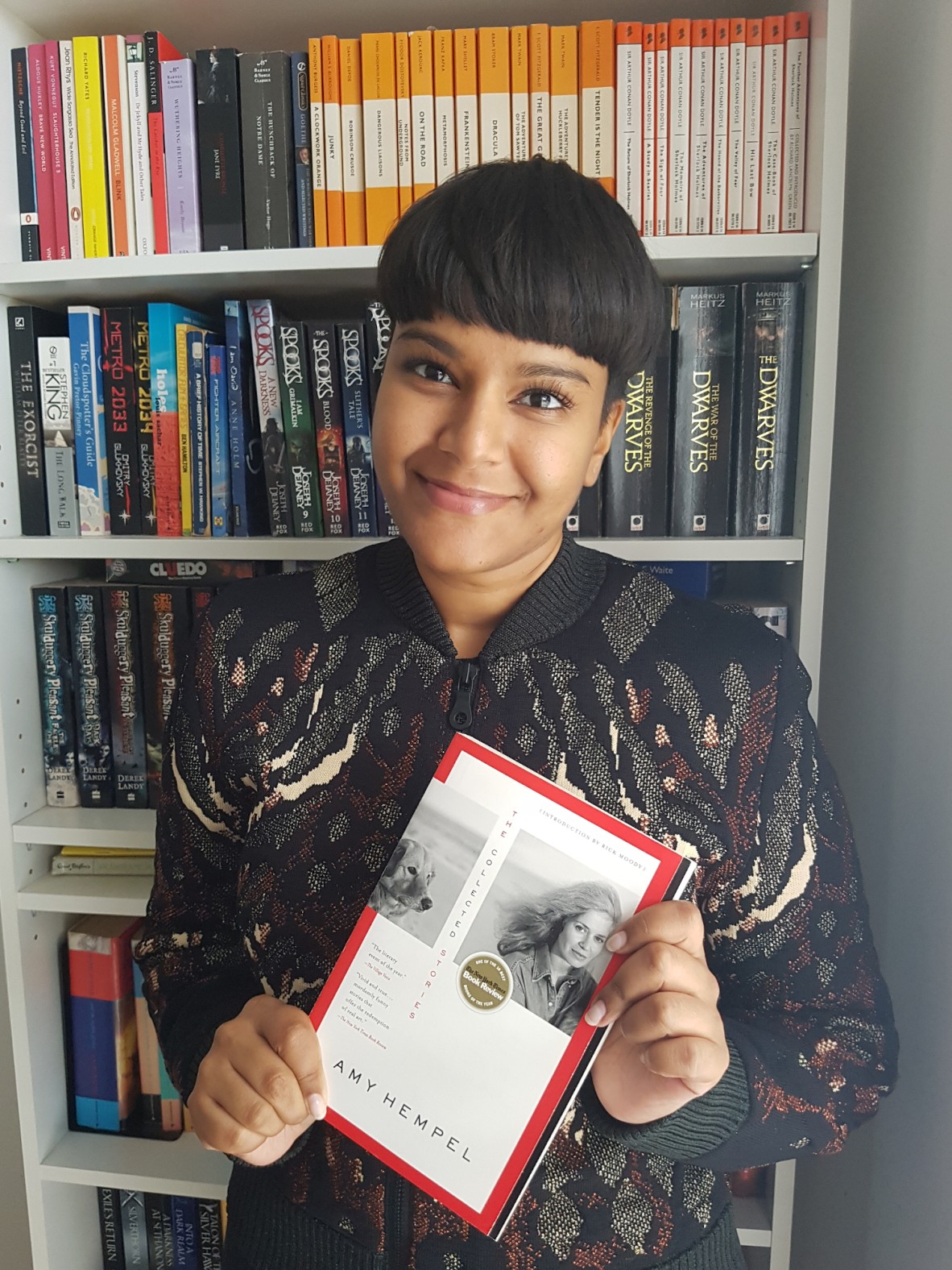 Shastra Deo smiling and holding Amy Hempels book The Collected Stories