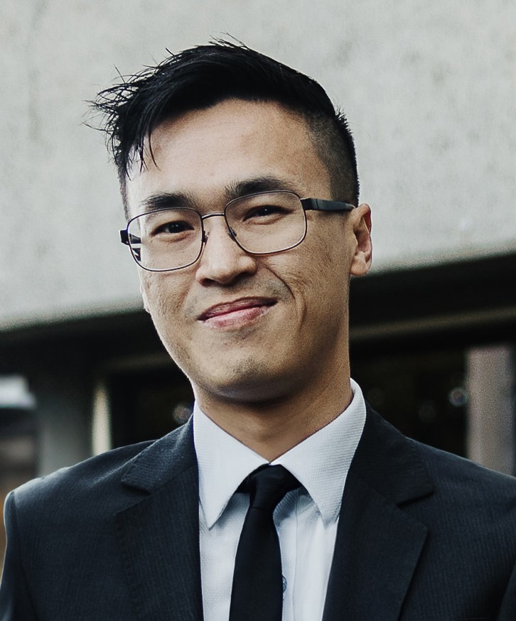 Image of Siang Lu who is wearing a black suit with a white shirt. He is smiling.