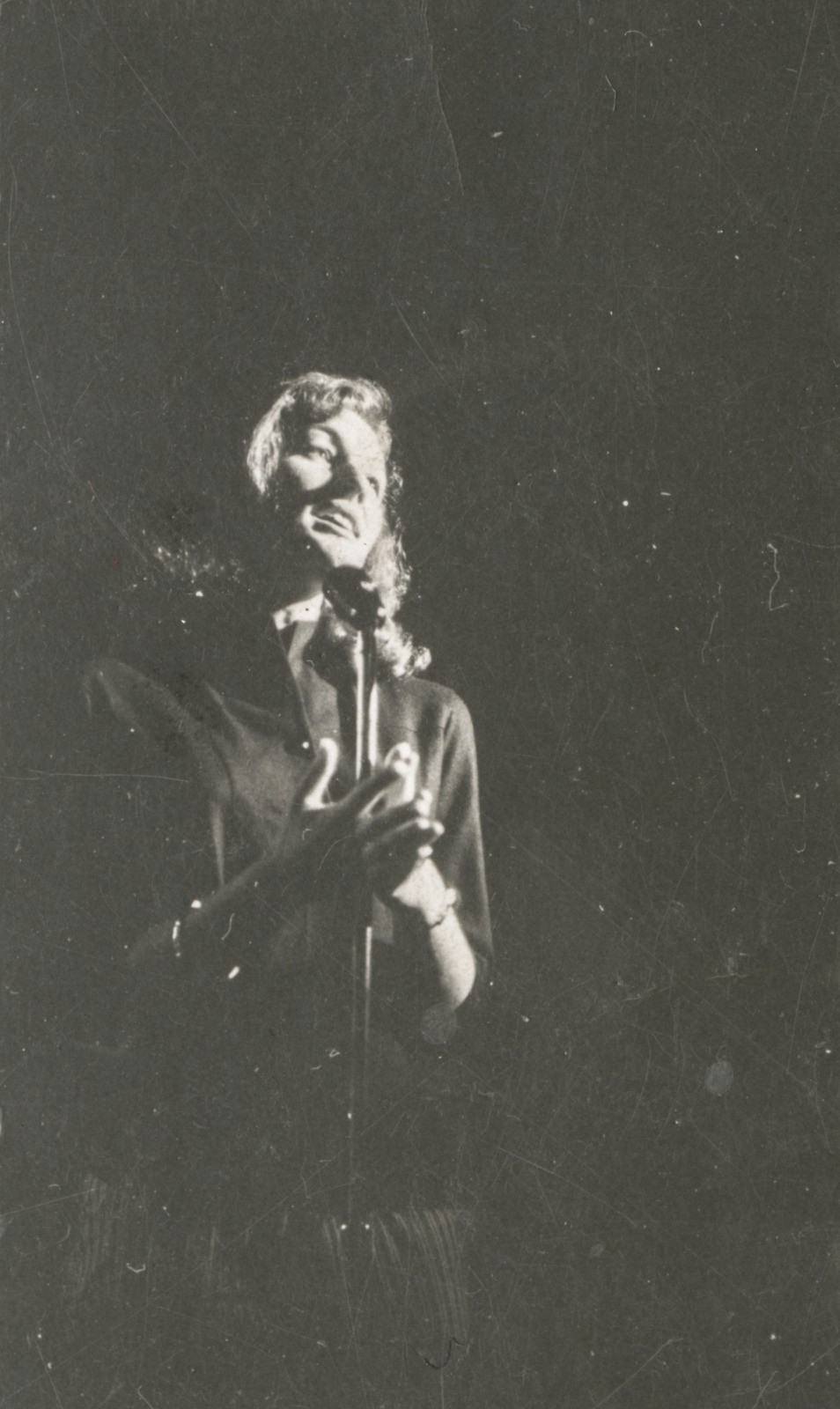 Black and white photograph of Paula Langlands performing on stage at the Primitif Coffee Lounge, Brisbane