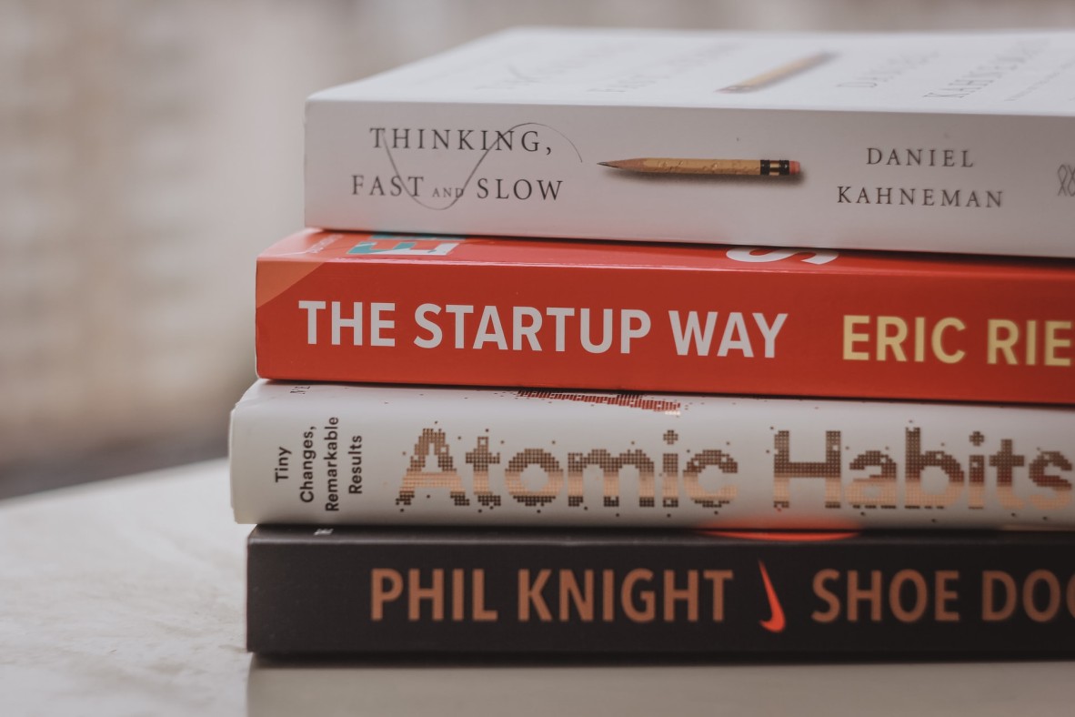A stack of four business books
