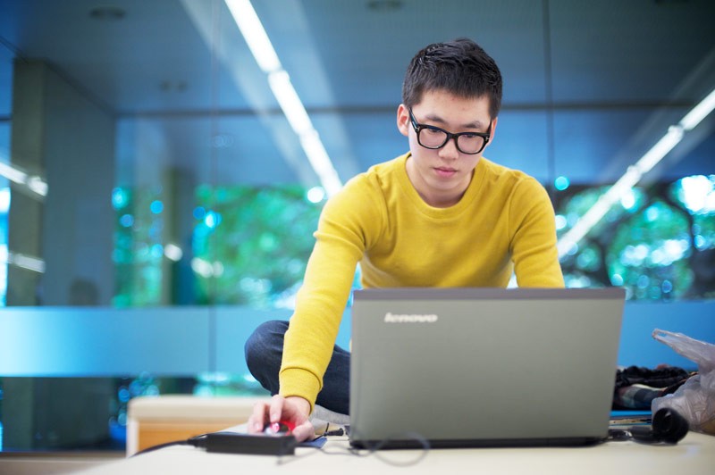 Man using laptop in the State Library of Queensland.