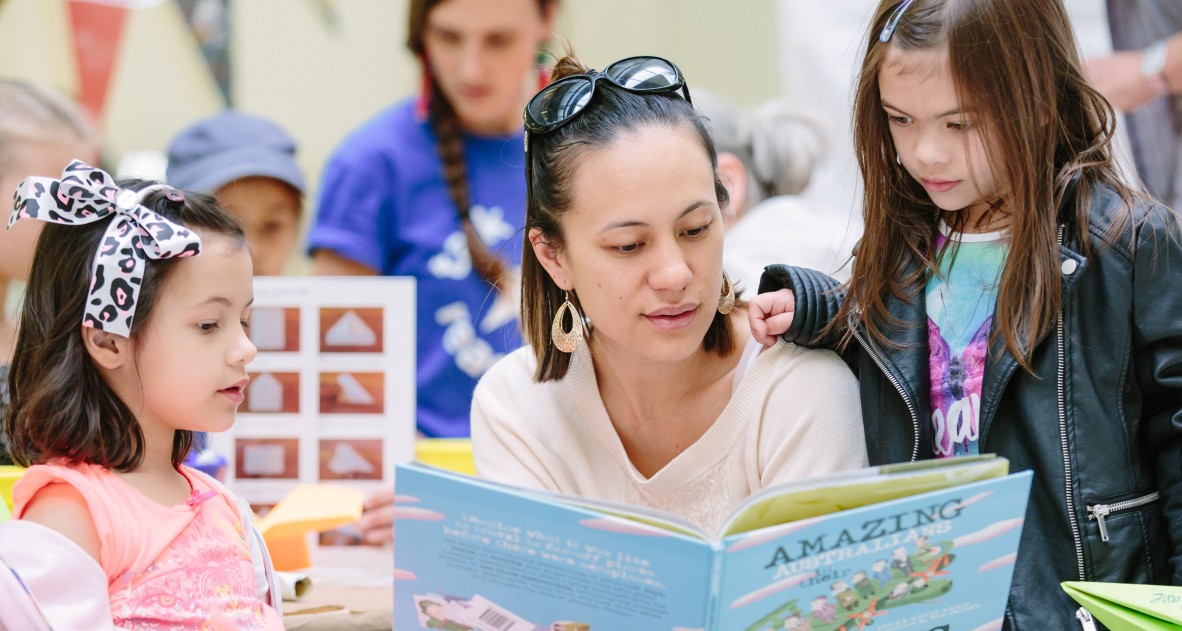 A mother reading with her two daughters at State Library. Photo by Stephen Henry Photography.