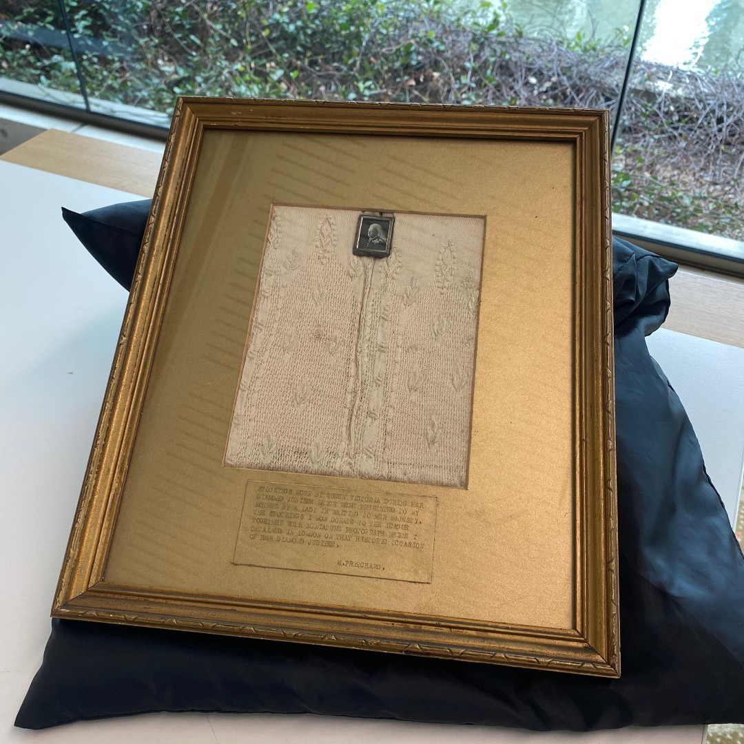 a framed and mounted pair of stocking that once belonged to Queen Victoria of the British empire 