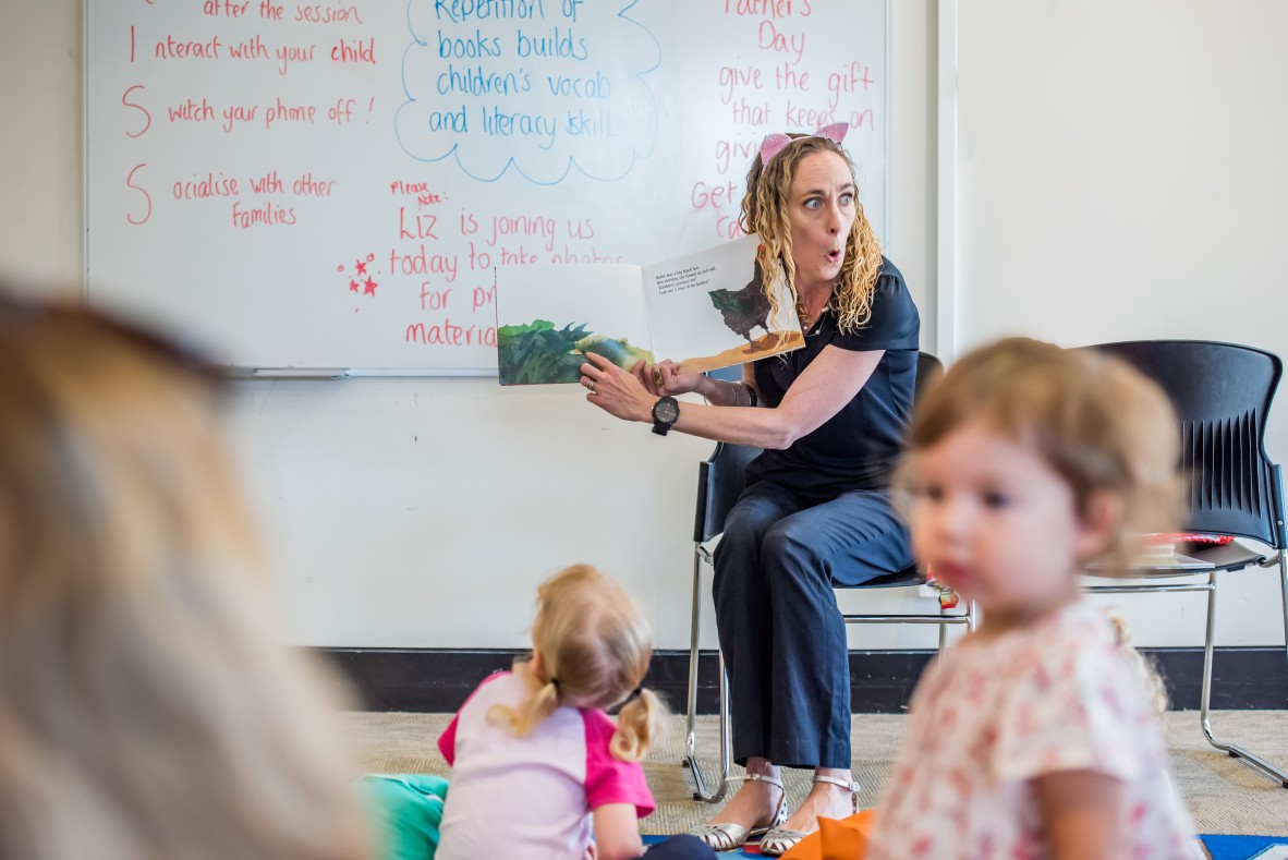 Librarian reading a book at a storytime session