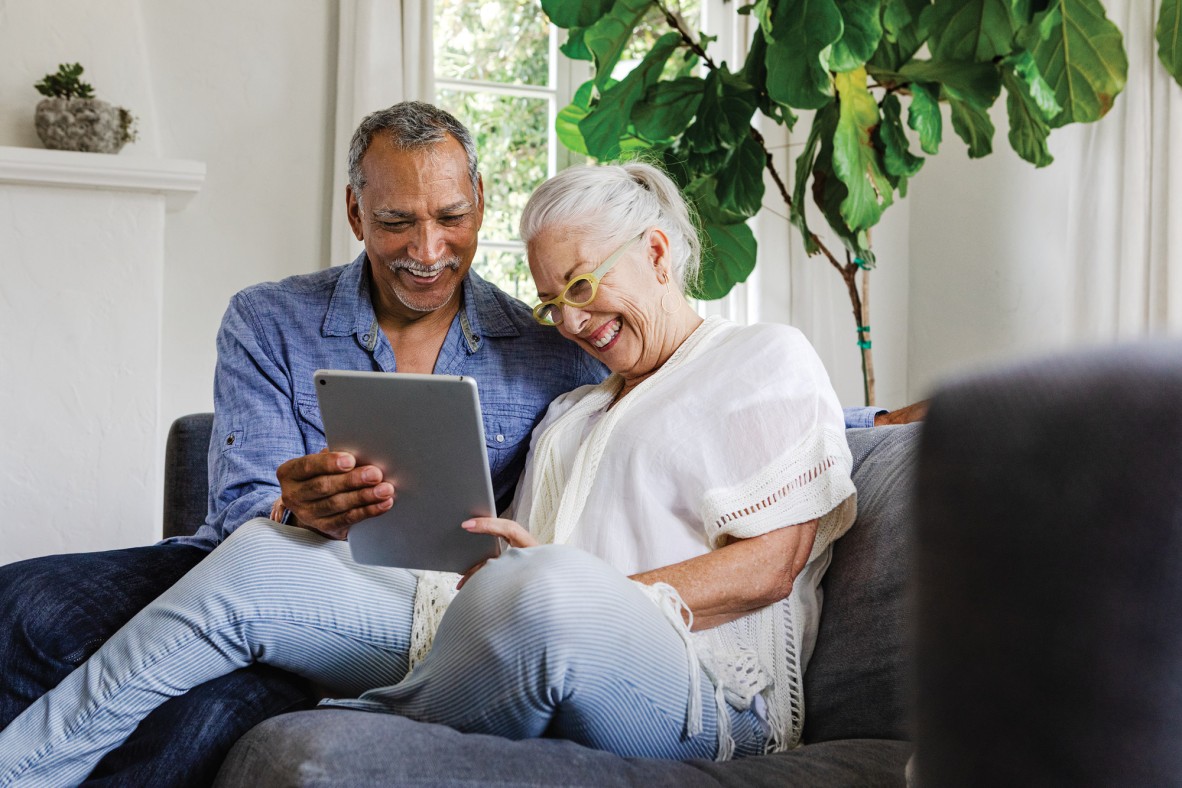 Image of an older man and woman looking at a tablet device