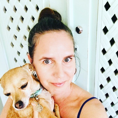 Tabitha Bird holds her chihuahua, Lion, who is light brown with a green collar