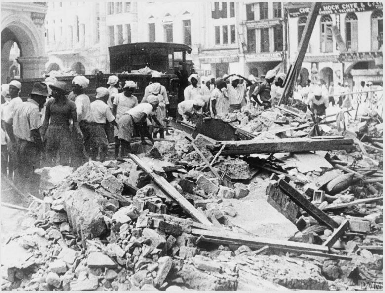 workmen clean up a destroyed building in a street, 1942 