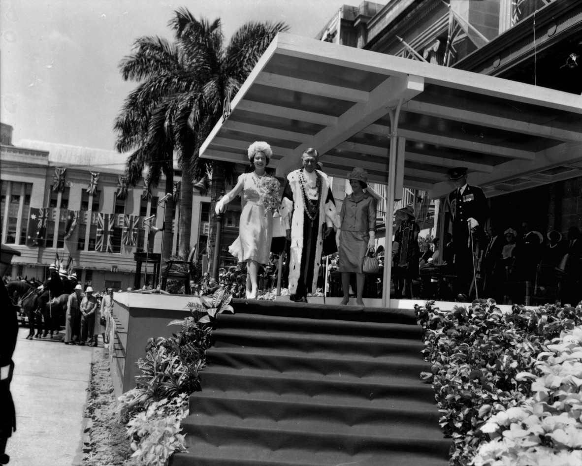 the queen walks down some steps 