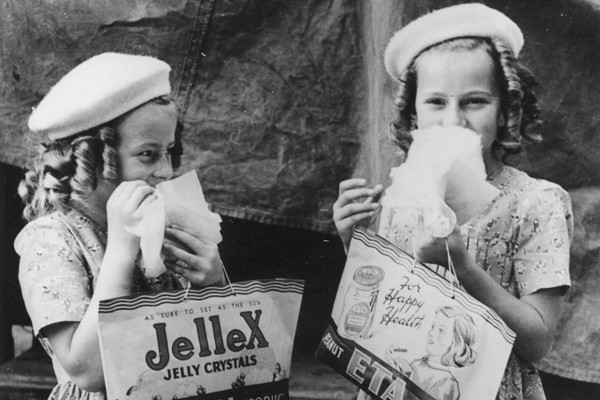 Two young girls enjoying themselves eating lollies at the RNA Show