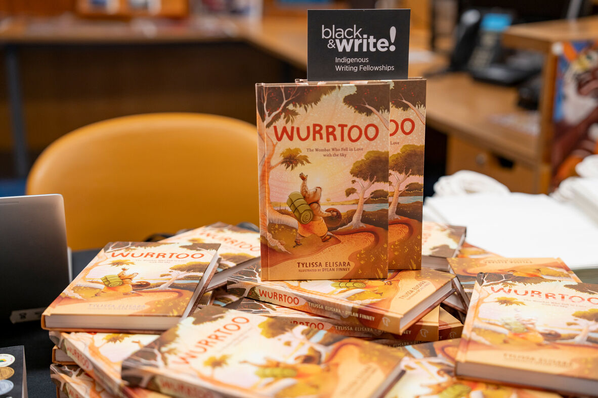 Wurrtoo books piled on table with black&write! bookmark