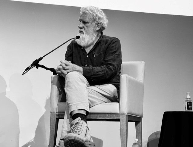 A black and white image of Uncle Bruce Pascoe sitting down and speaking at Brisbane Writers Festival in 2021 