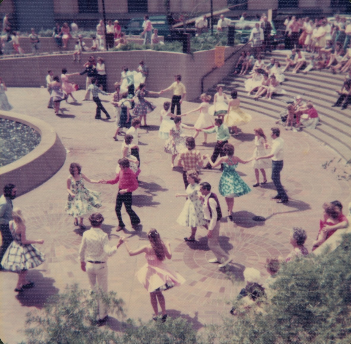 people swing dancing in a concrete square 