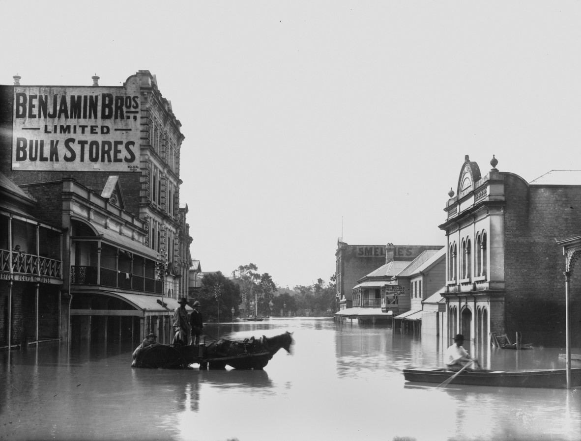 Two men with a horse and cart stand in flood waters in brisbane city 