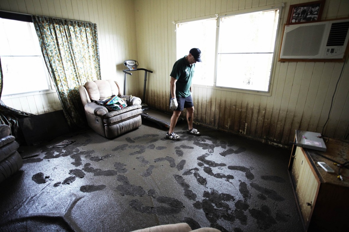 Condamine publican Shane Hickey surveying the flood damage in his lounge room, Condamine, Queensland, 2011