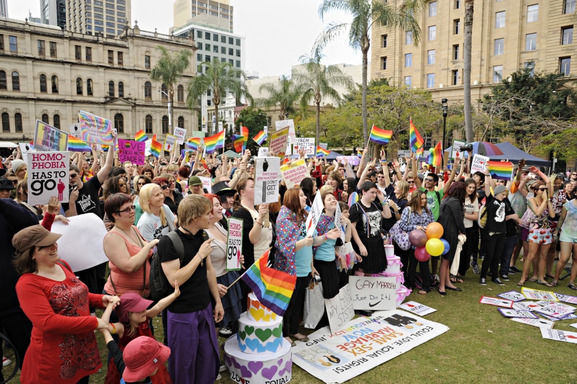 a large group of people wave rainbow flags in support of gay marriage