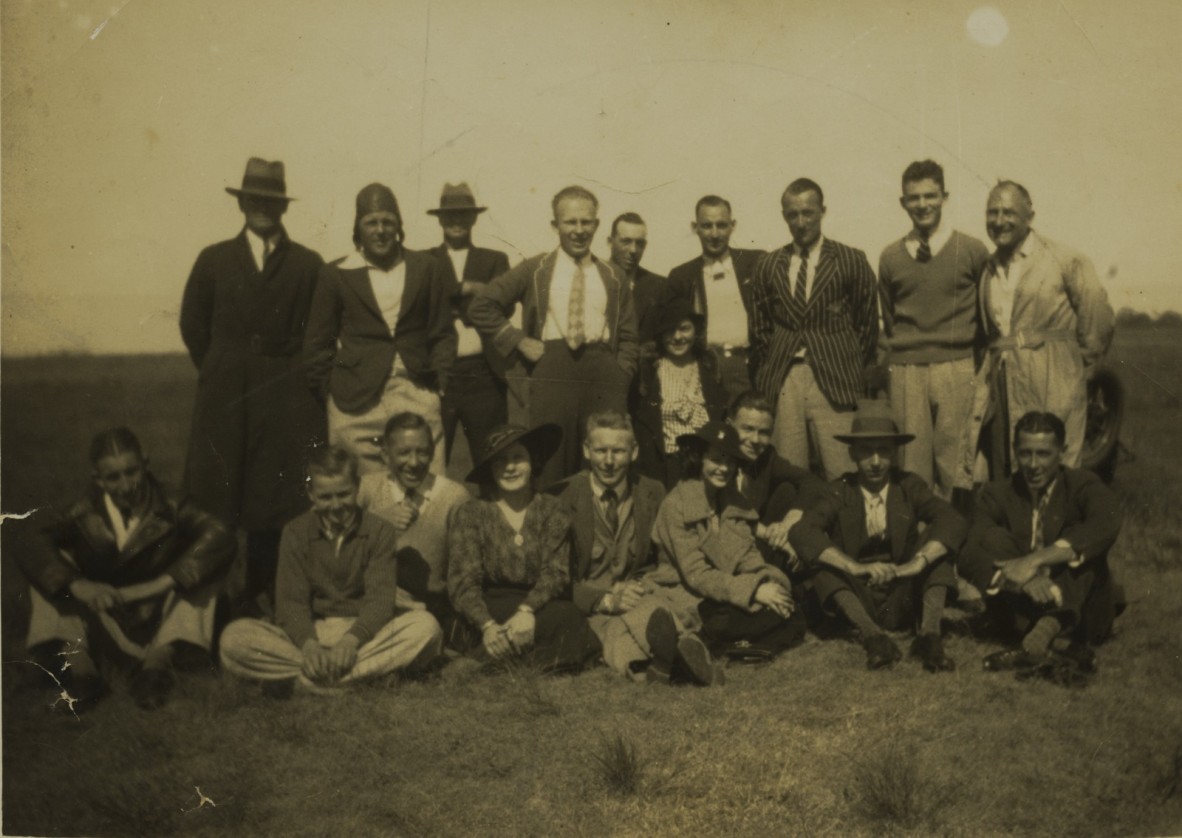 A group of people pose for a photo in a field The photo is black and white from 1936