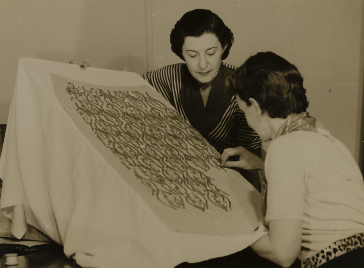 Designer Ivy Hassard looks on as a seamstress embroiders designs into fabric