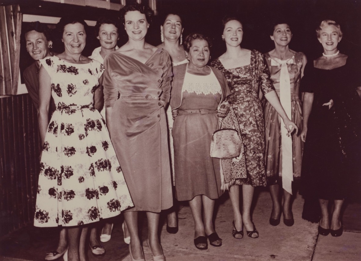 Group of women pose for a photo in evening dresses black and white photo from 1958