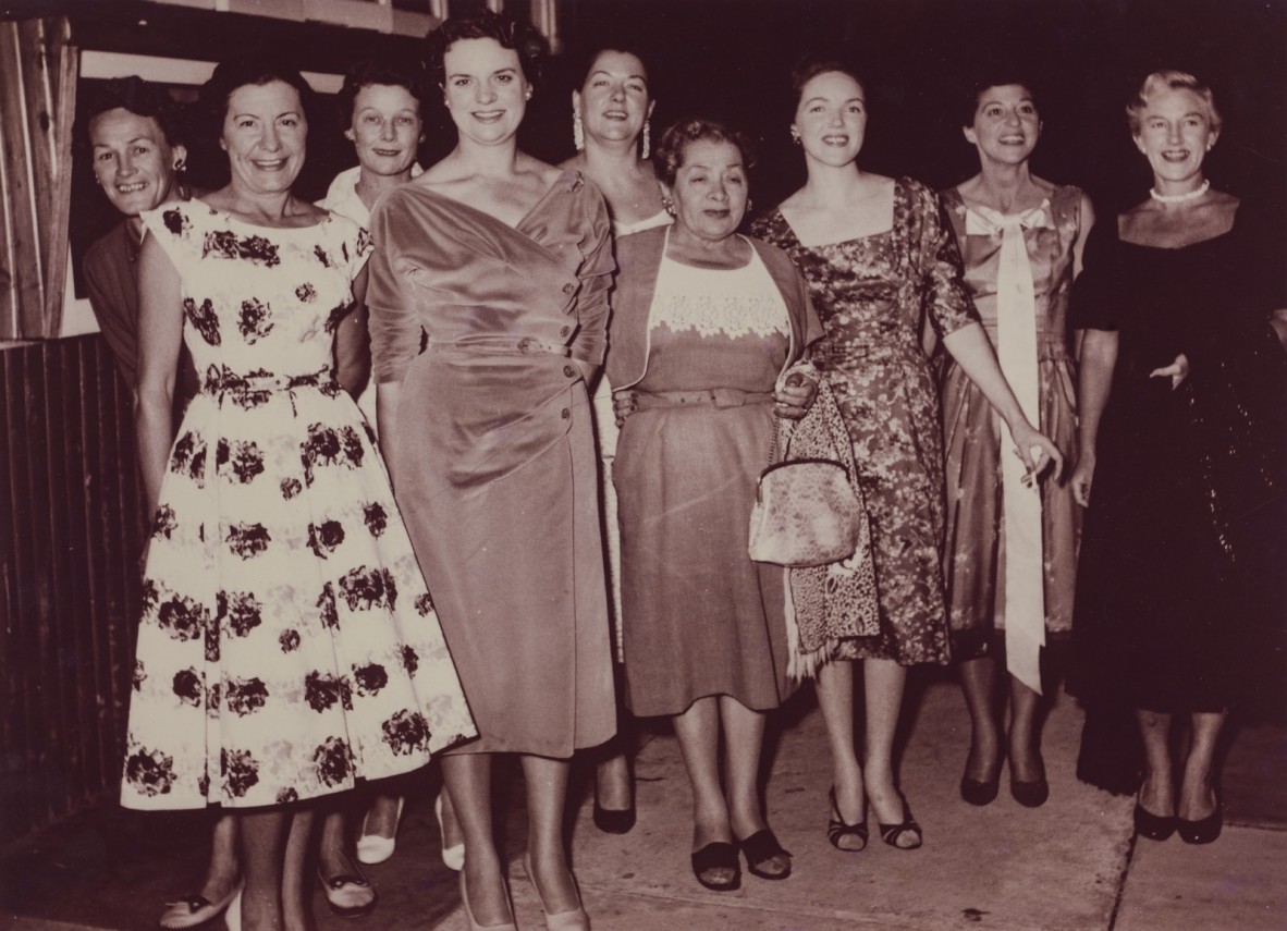 Group of women pose for a photo in evening dresses, black and white photo from 1958