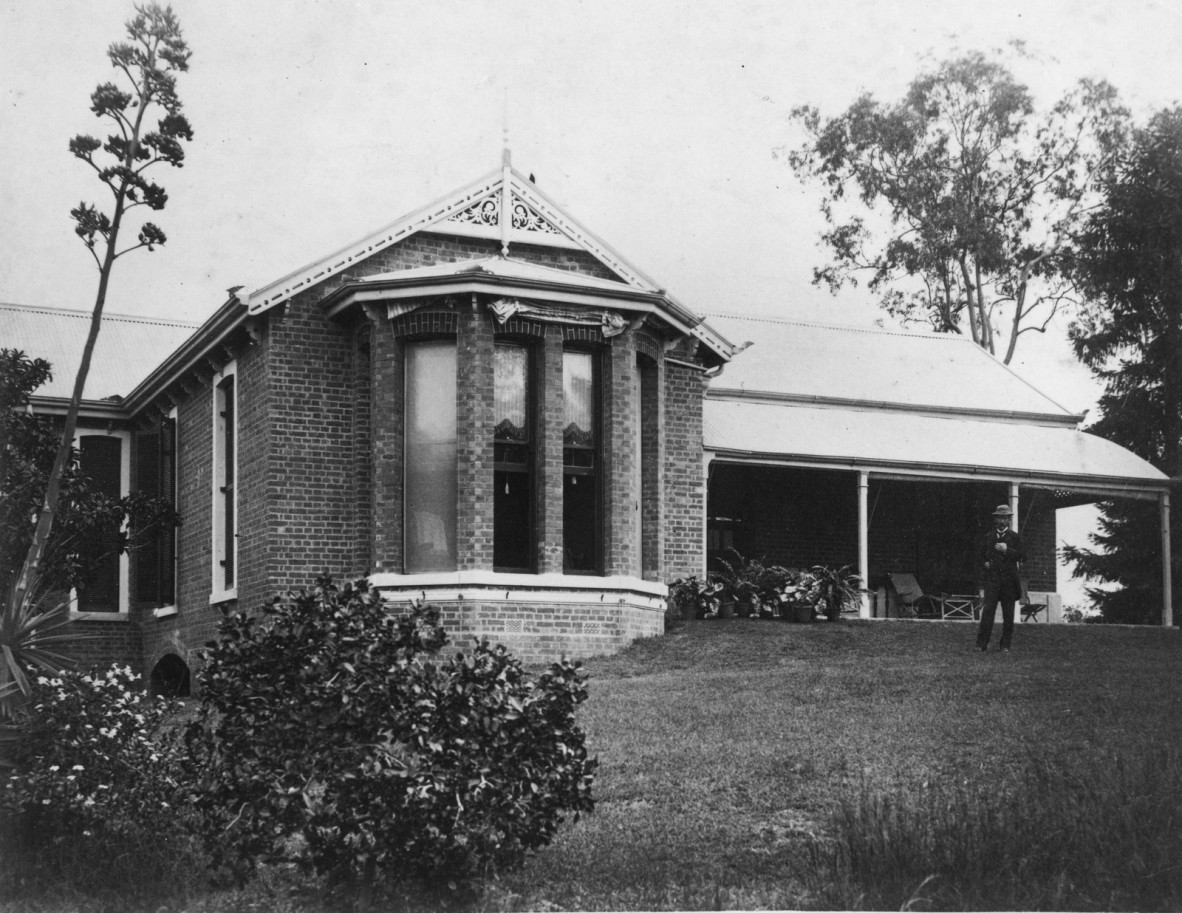 A man on grass standing outside House