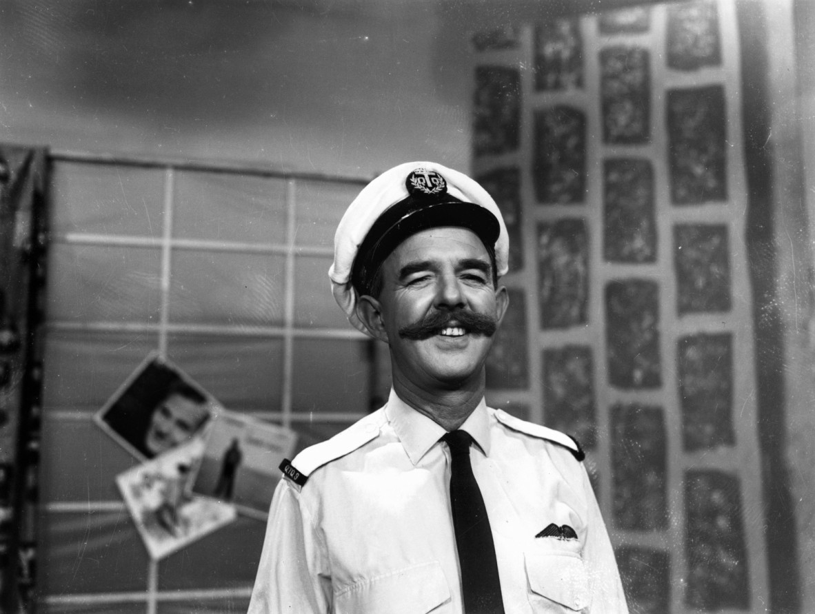man with moustache and naval costume poses for camera
