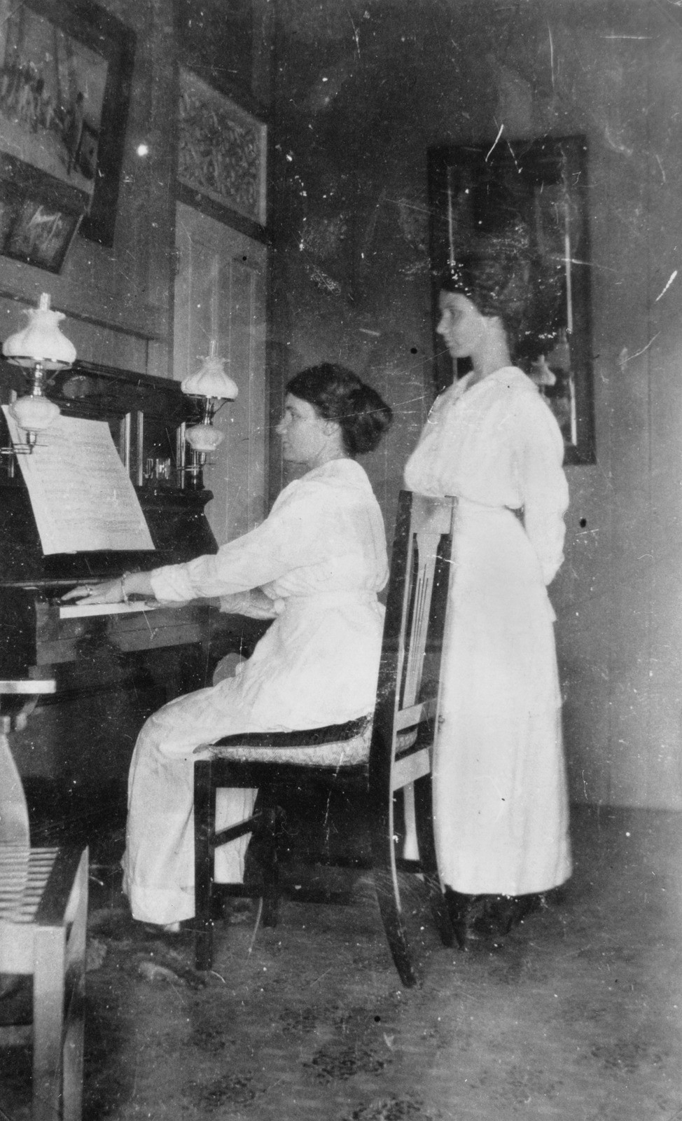 Olive Victoria Filsell Sedgley plays the piano at her home in Taringa Brisbane while her sister Lydia Goodliff Filsell Sandercock watches 1916