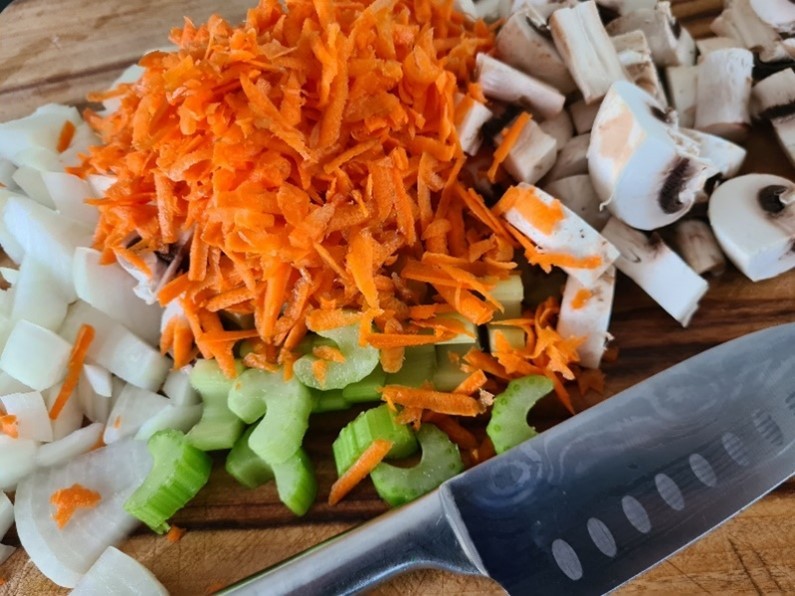 A chopping board with chopped vegetables
