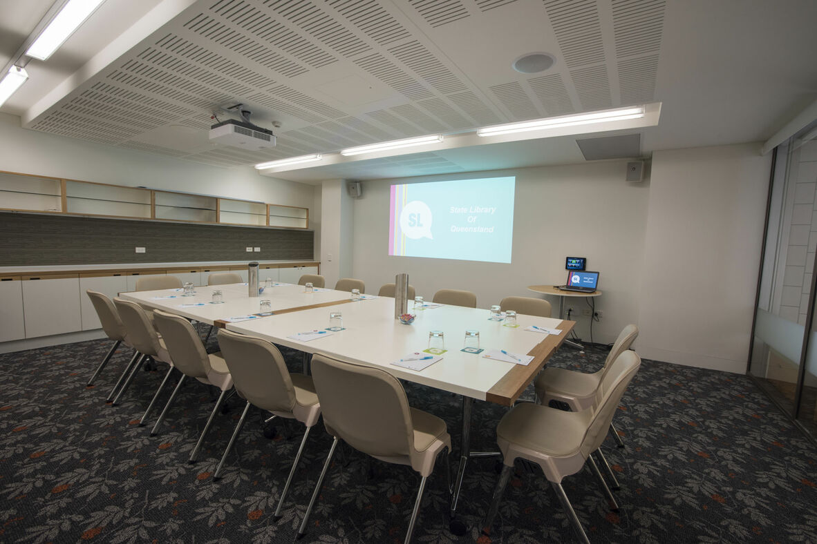Meeting room 1A at State Library with tables and projector.