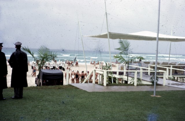 view of a white undercover area overlooking a beach with surf life saving competitors 