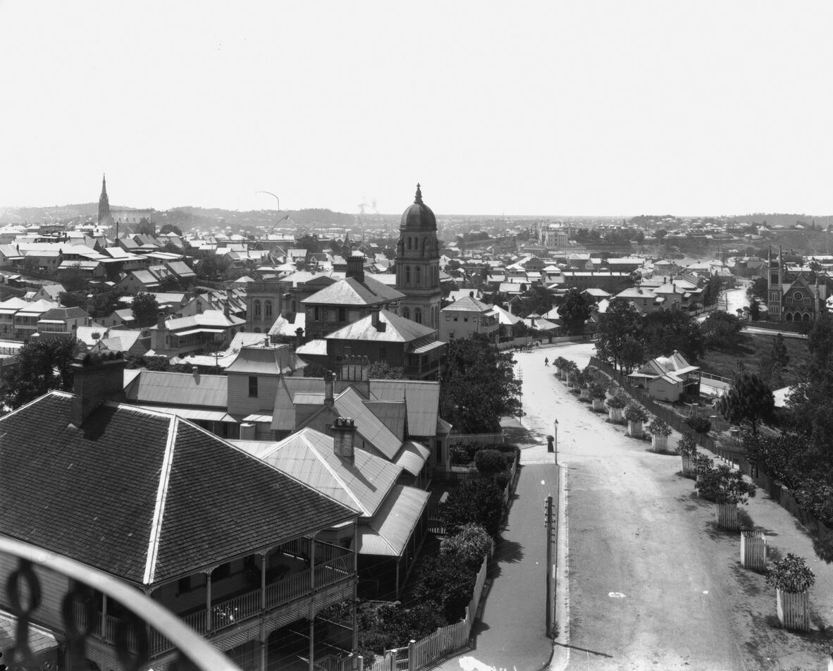 A view over houses and other buildings with a road in between