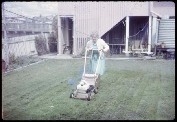 Woman mowing the lawn with an electric lawnmower ca1975  Photographer unidentified  John Oxley Library SLQ  MMS ID 99198313402061