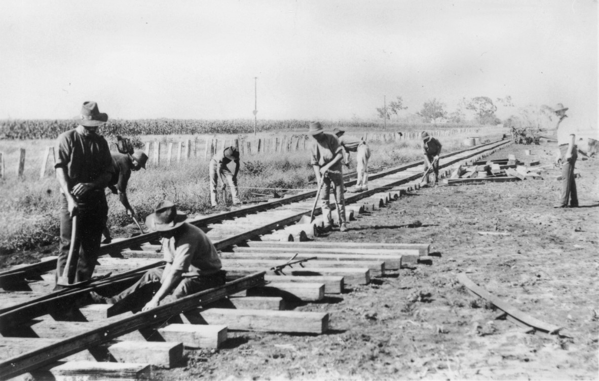 Black and white photo of railway workers laying tracks
