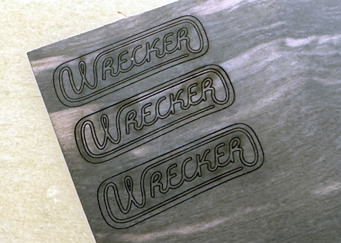 A photo of a laser cut logo that says Wrecker