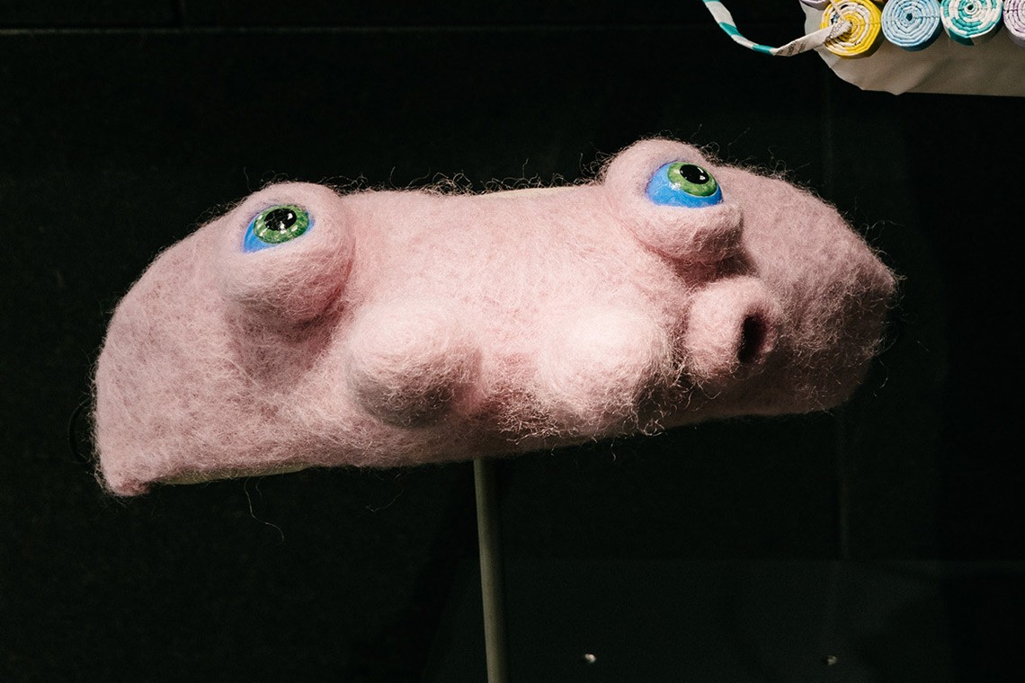 The Covid 19 mask Alienation is a reflection on a shift from feelings of anxiety to curiosity and hope during self- isolation  The face mask is constructed from crocheted and felted pink wool with acrylic painted blue eyes