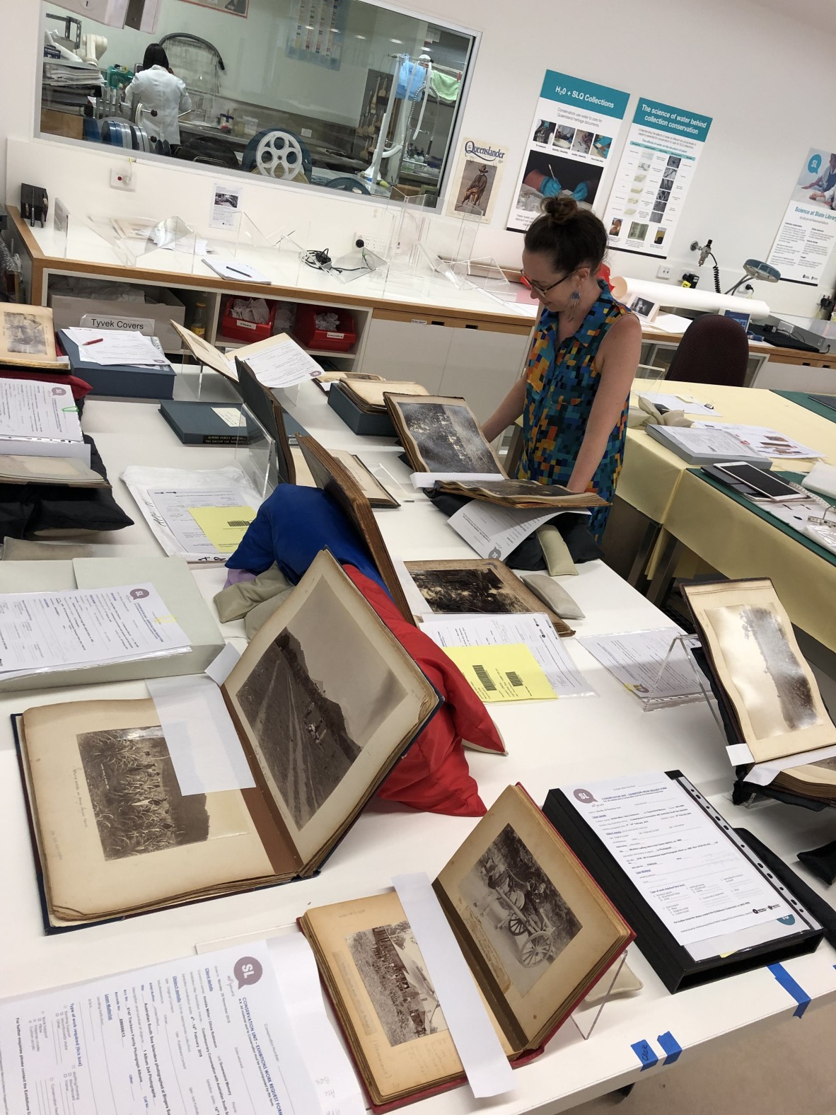 SLQ staff Kelly Leahey looking at photo albums