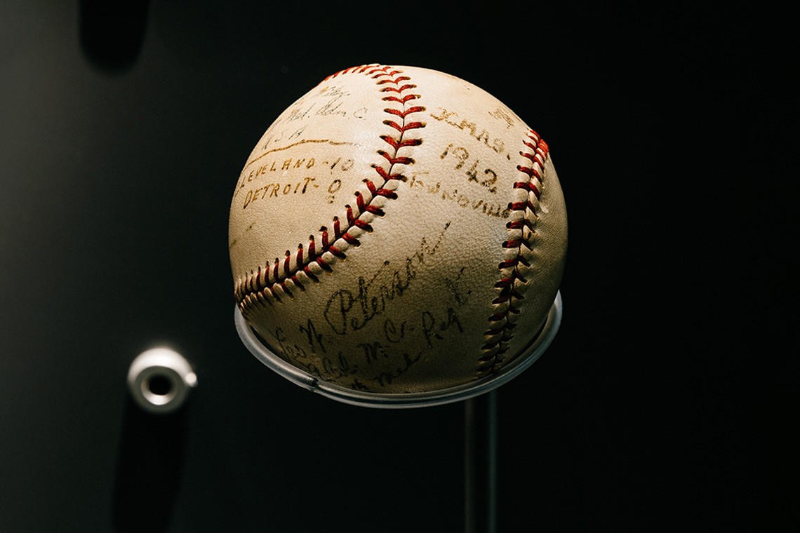 An American baseball which was used by some of the first American servicemen stationed in Townsville during a game played on Christmas Day 1942   The baseball is cream coloured with red stitching and has been autographed by the players in black ink