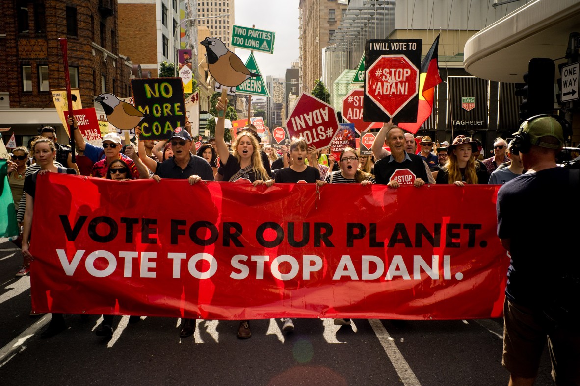 Bob Brown and protestors marching behind Vote For Our Planet banner down Edward Street