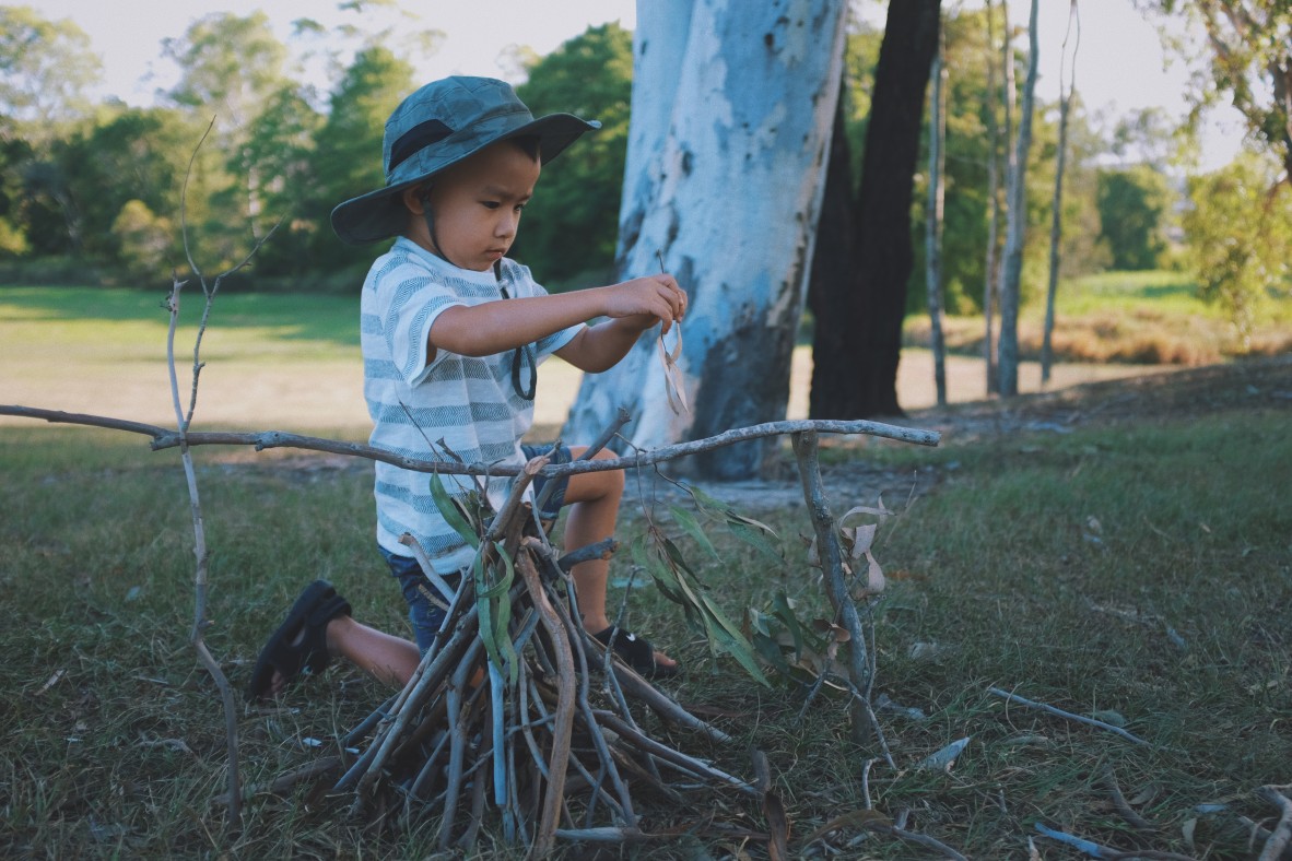 Young boy playing with sticks outside