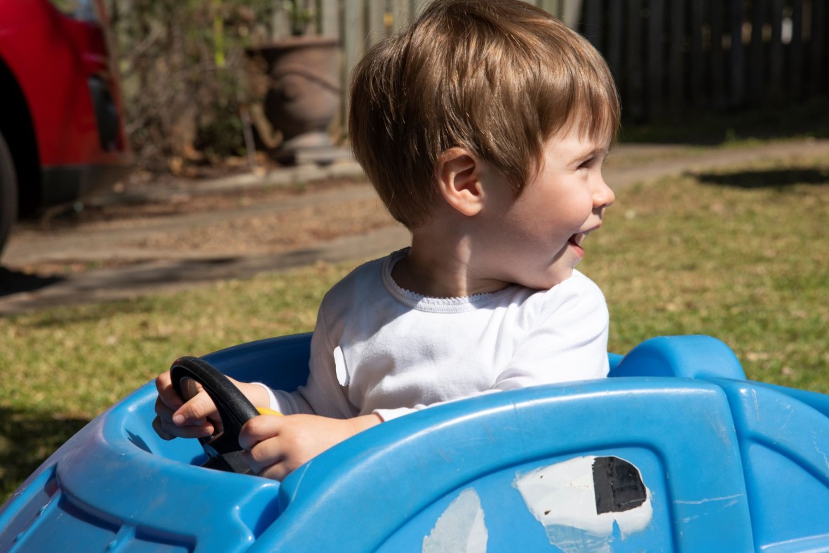 Toddler driving a toy car