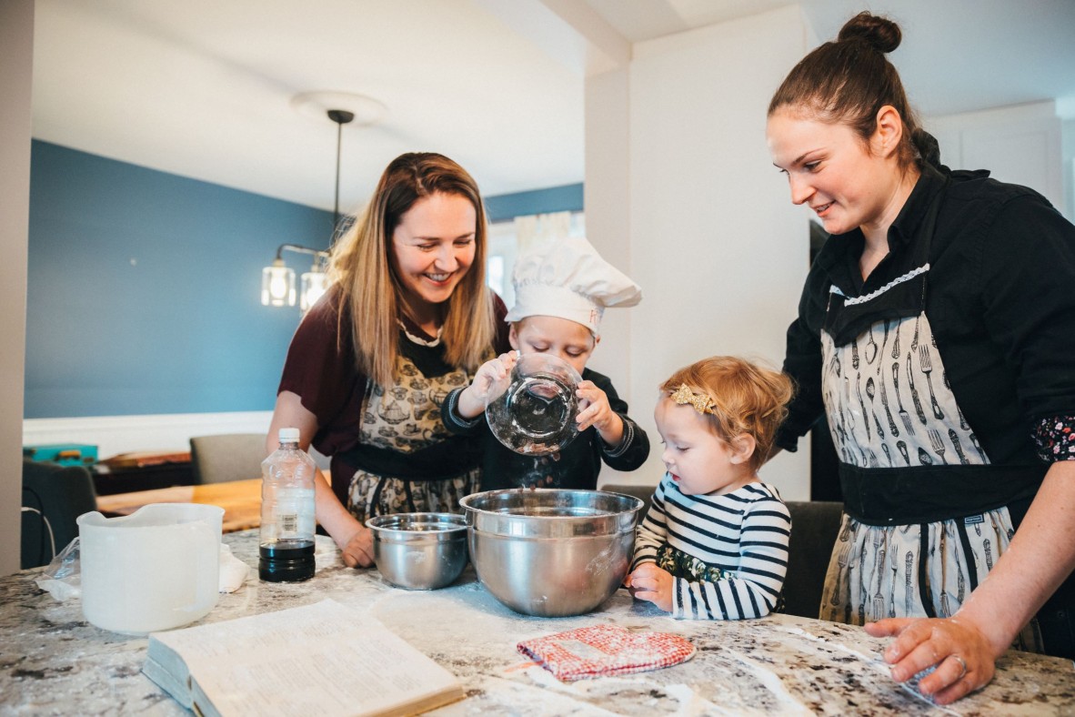 Family with two children cooking together in the kitchen