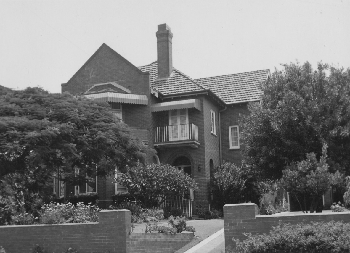 A two story house with a chimney and rounded windows on the ground level floor
