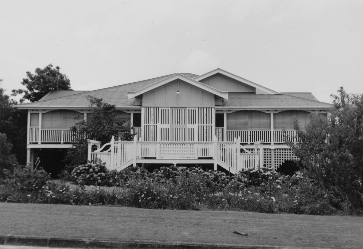 A house with staircases on both sides and lots of shrubbery