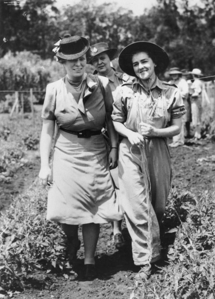 two women walk through a field 