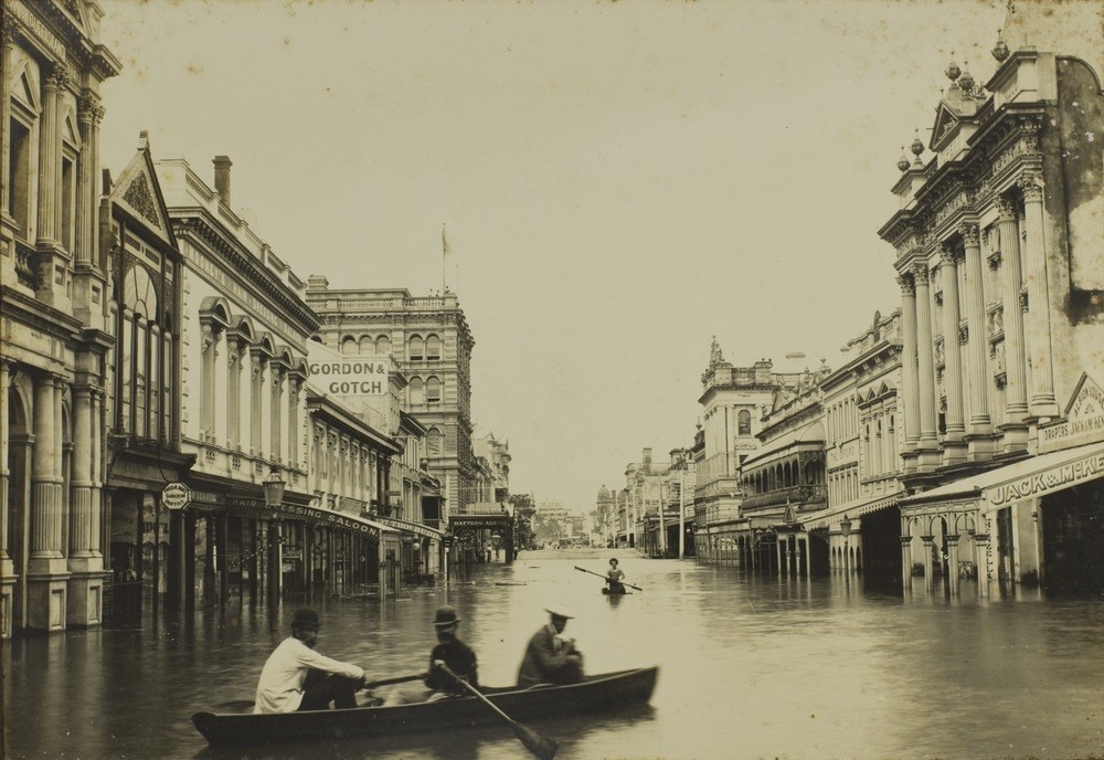 men row a canoe in a flooded street in 1893 Brisbane 
