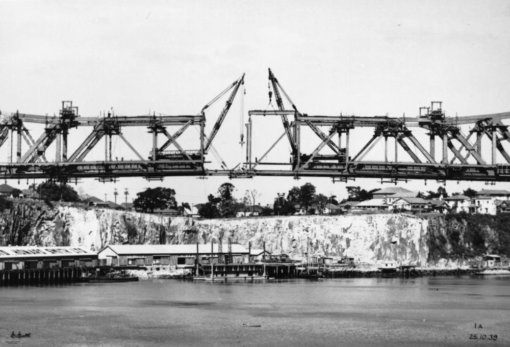 The almost-completed Story Bridge, links Kangaroo Point on the right to Fortitude Valley and New Farm on the left. The suspended span is being joined with a centre panel (1939)