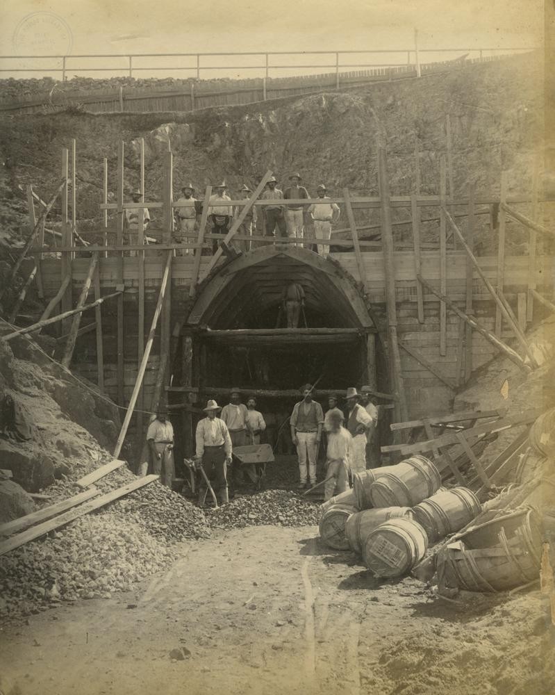 Workers standing outside the entrance to a railway tunnel under construction Brisbane ca. 1884.