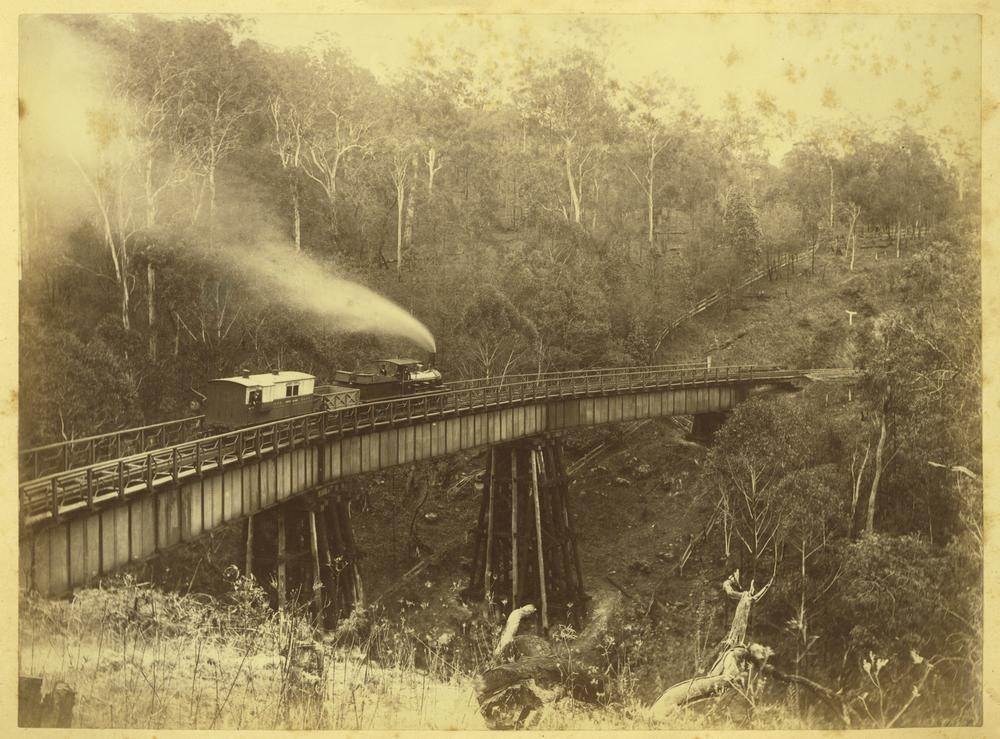 Locomotive coal wagon and carriage on the bridge in Main Range ca1880